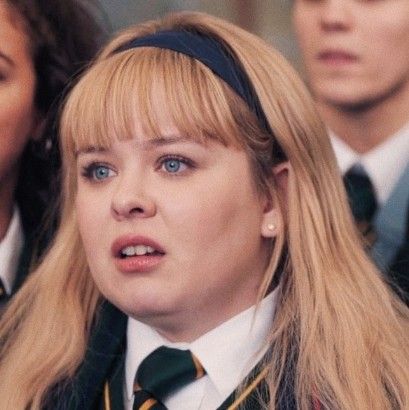 a woman with long blonde hair wearing a school uniform in front of two other people