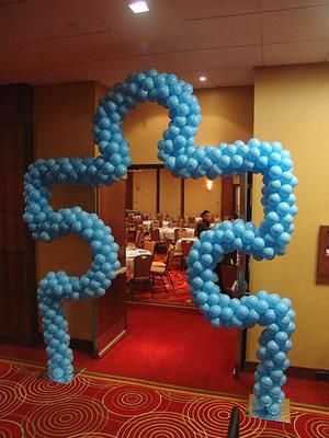 blue balloons are arranged in the shape of letters on a red carpeted room floor