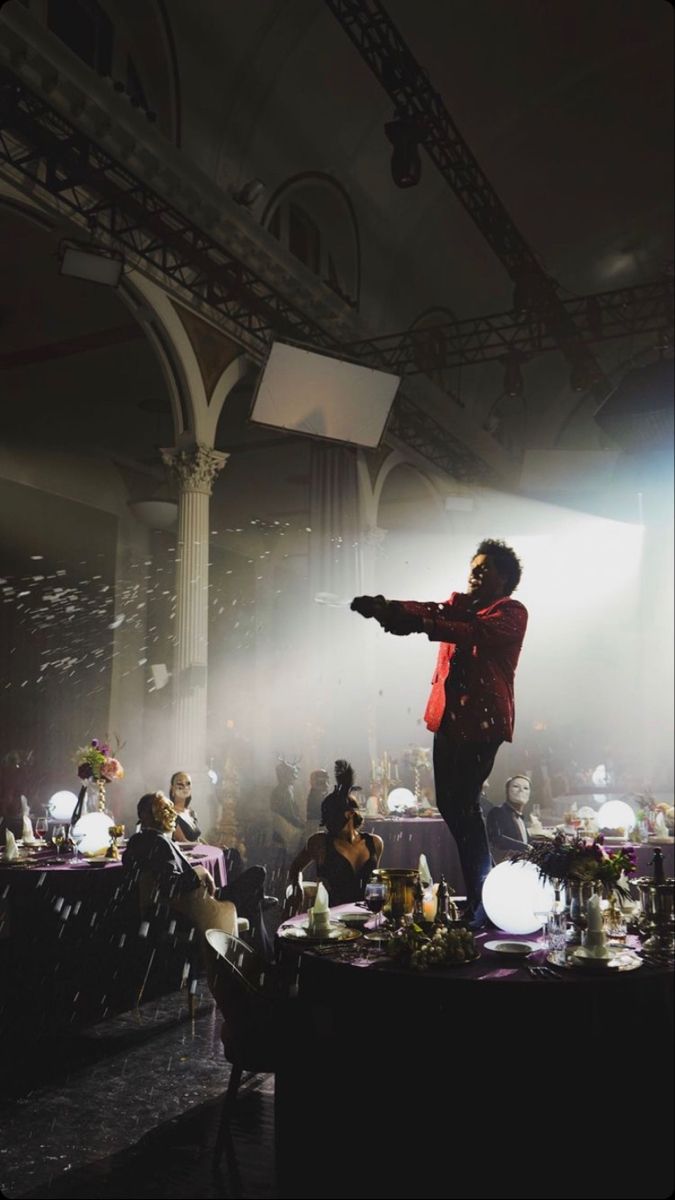 a woman standing on top of a stage in front of a crowd at a party