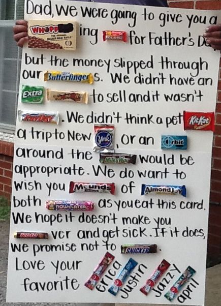 a man holding up a sign with candy bars on it