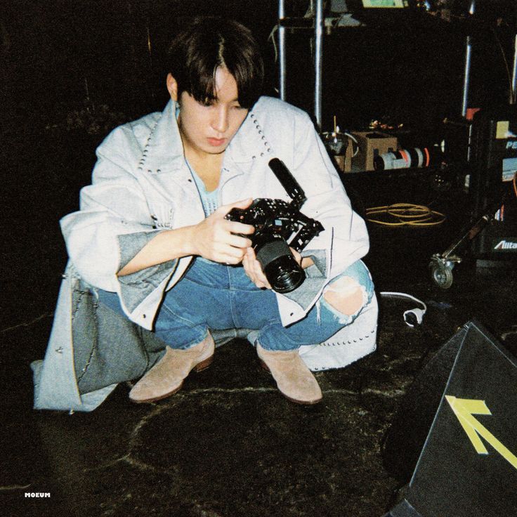 a person kneeling down with a camera in their hand