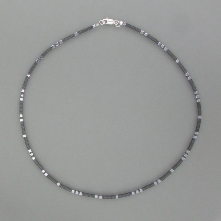 ! This sporty necklace consists of angular hematite discs between which polished silver cubes appear in a regular rhythm. This creates an exciting light/dark contrast, but the chain still looks harmonious and balanced. It is closed with a practical carabiner closure and can be complemented by a matching bracelet and earrings. Dimensions edge length: 2 mm, length: 43 cm  Keywords chain, hematite, silver, cube, simple, sporty Regular Rhythm, Matching Bracelet, Polish Silver, Matching Bracelets, Delicate Necklace, 925 Jewelry, Silver 925, Light In The Dark, Favorite Jewelry