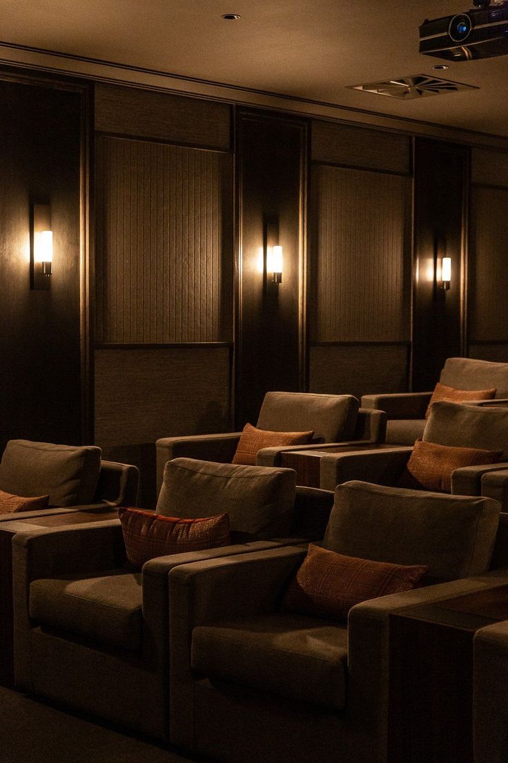 an empty movie theater with brown seats and wooden paneling, lights on the wall