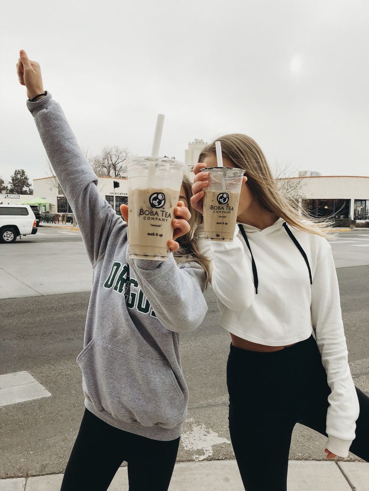 two people holding up drinks in the air