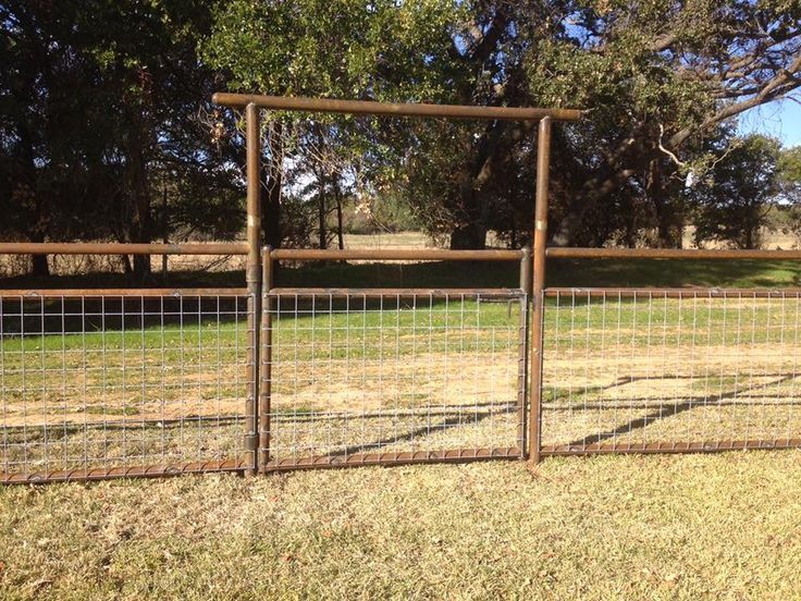 a fenced in area with grass and trees