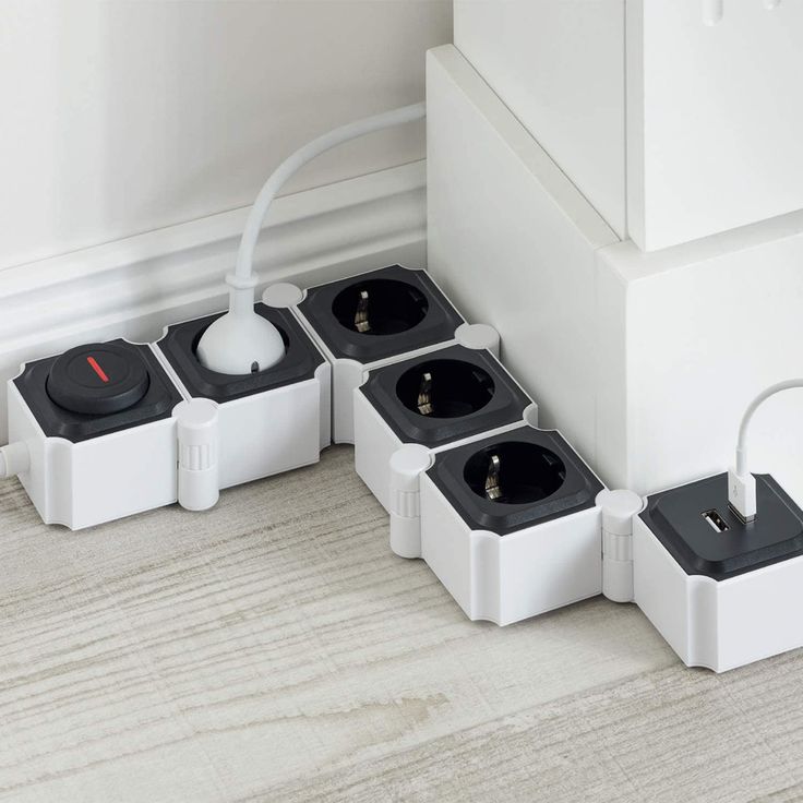 four electrical outlets are connected to each other on the floor in front of a wall