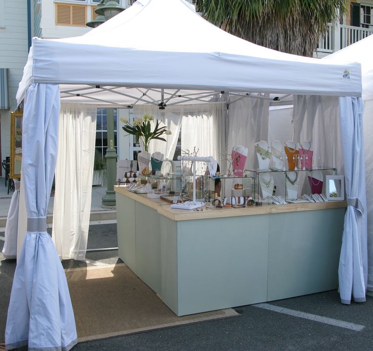 a white tent is set up with items for sale