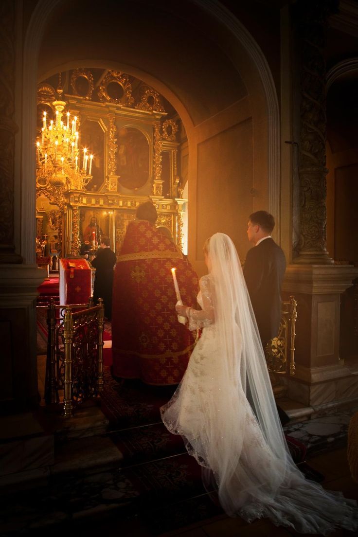 a bride and groom standing in front of the alter