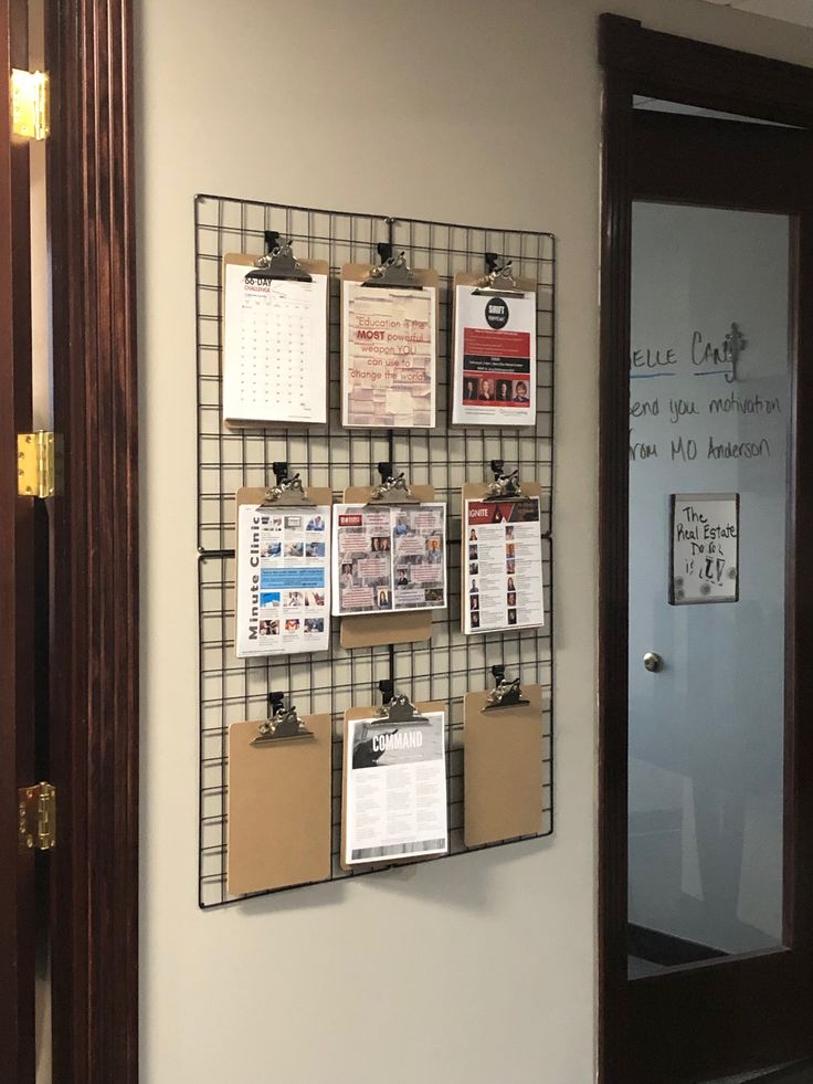 a bulletin board mounted to the side of a wall next to a door with clippings on it