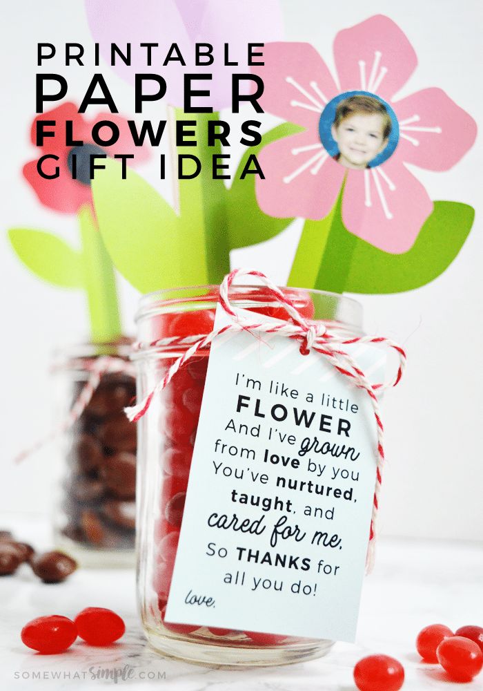 a jar filled with candy and flowers on top of a table