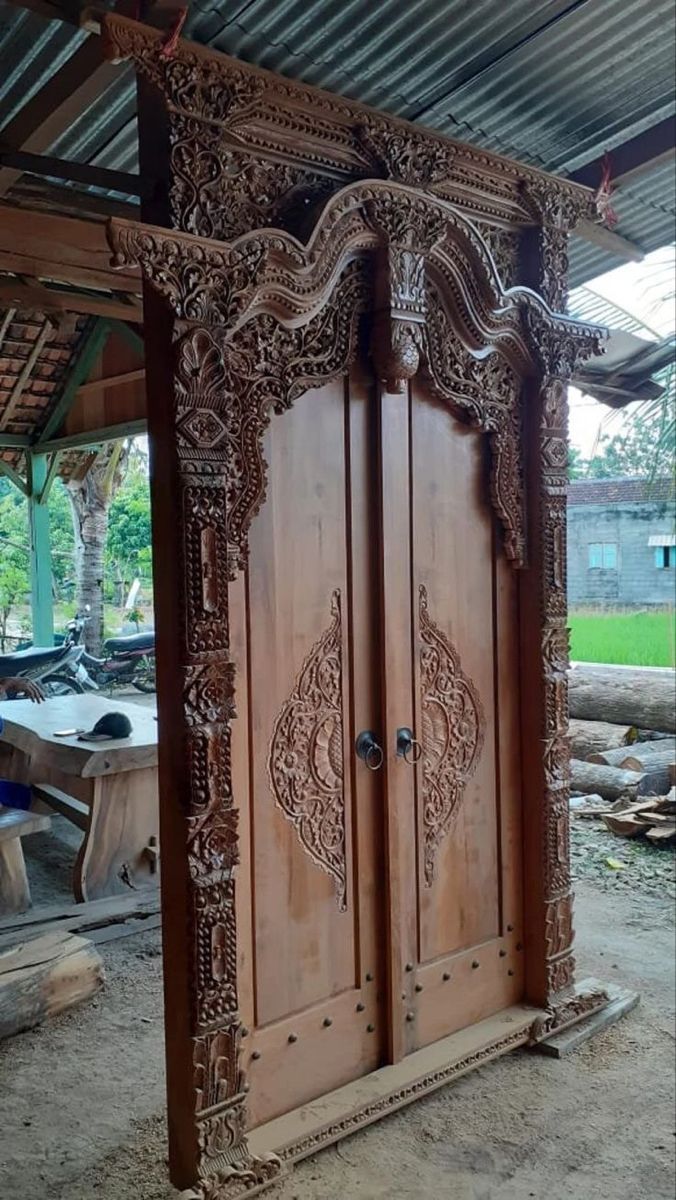 an intricately carved wooden door in the middle of a room with tables and chairs