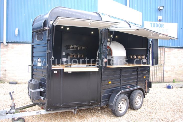 an outdoor kitchen on the back of a trailer