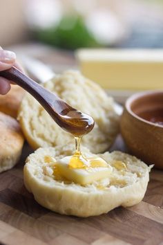 a person is dipping an egg into bread on a cutting board with butter and honey