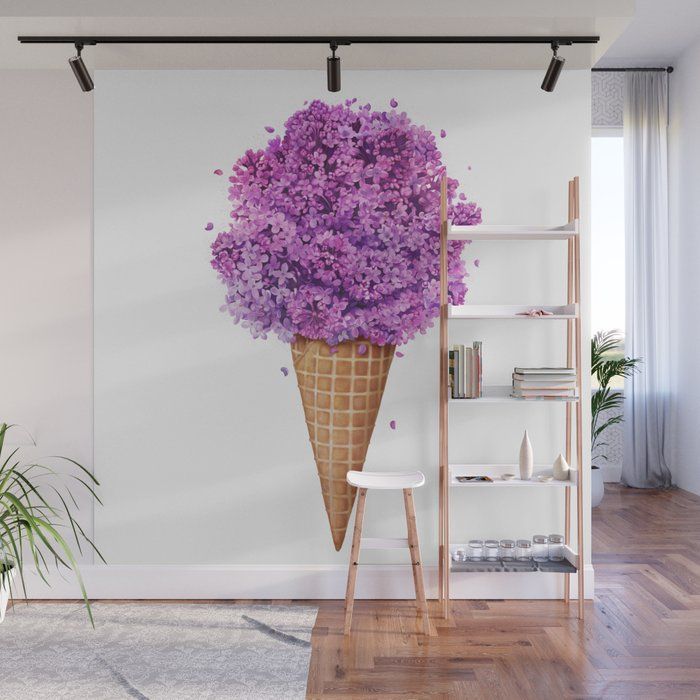 purple flowers in an ice cream cone on a white wall with wooden flooring and bookshelves