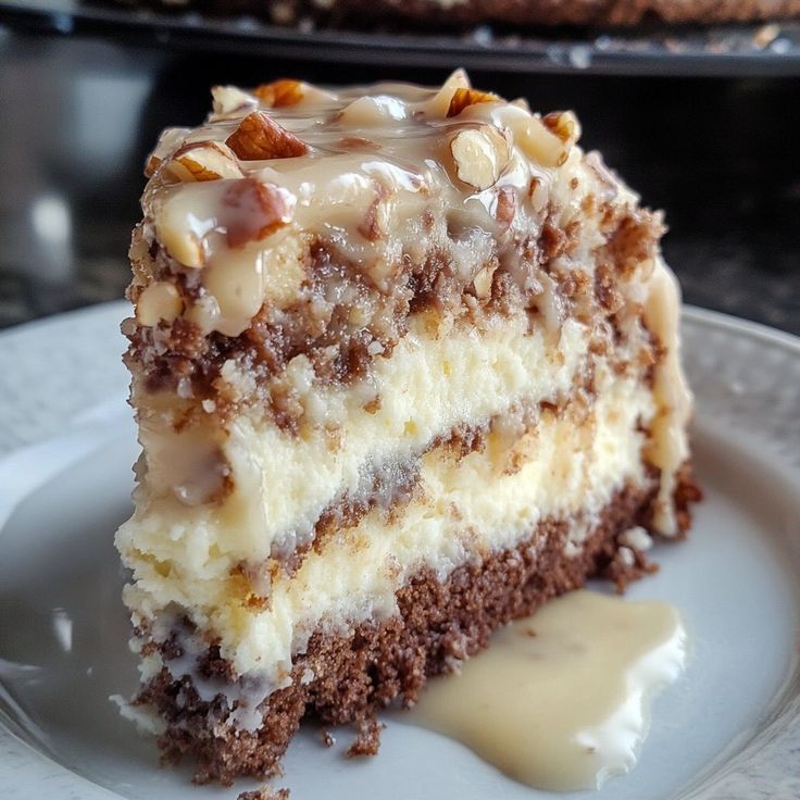 a piece of cake on a plate with some frosting and nuts around the edges