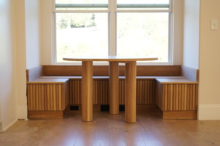 a table and benches in front of a window