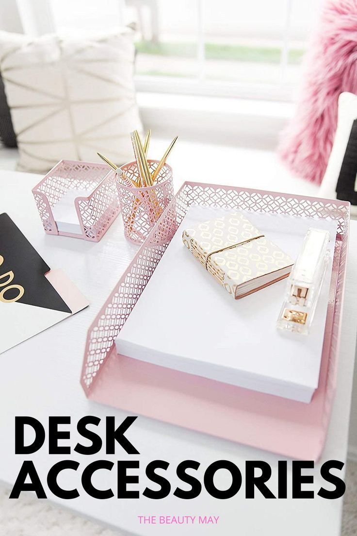 a white table topped with pink and gold trays filled with personalized notebooks