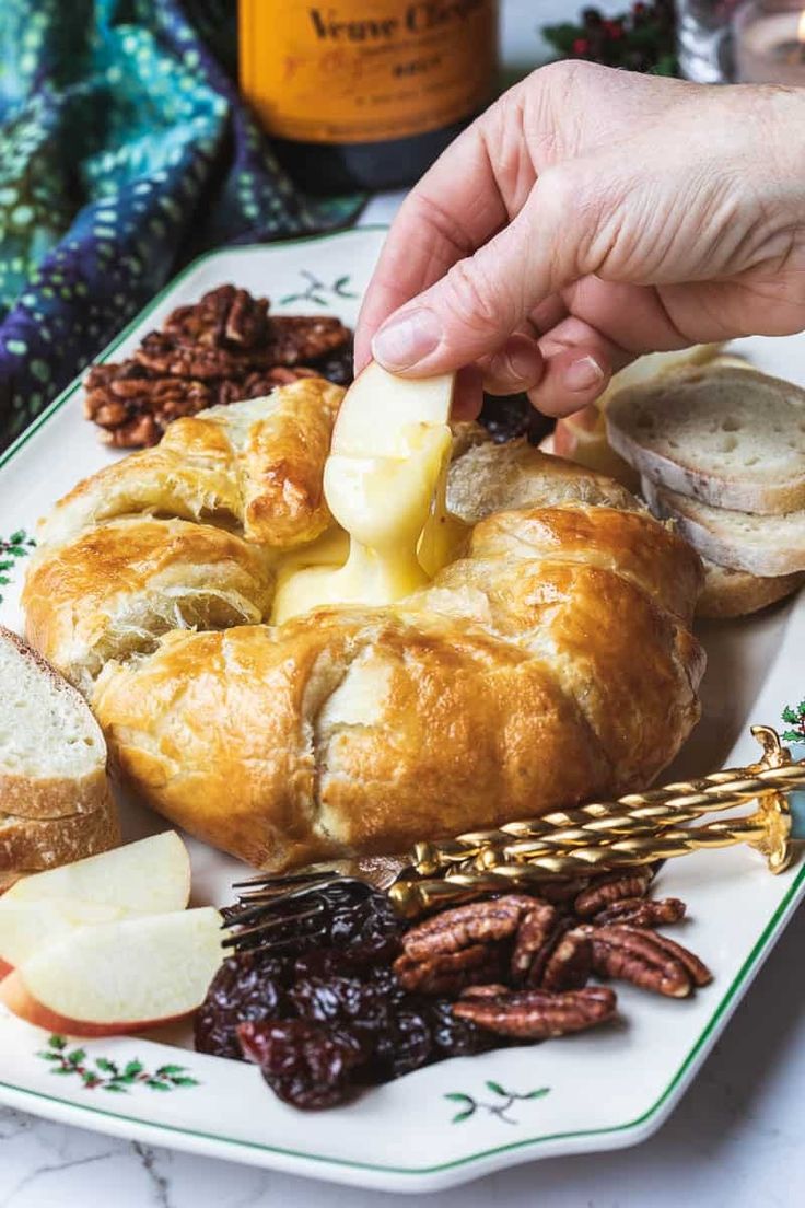 a person is pouring butter on some bread and fruit for desserts with pecans in the background