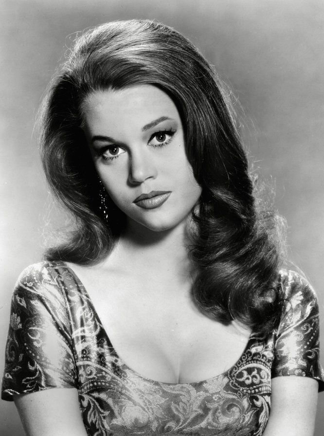 an old black and white photo of a woman with long hair, wearing a dress