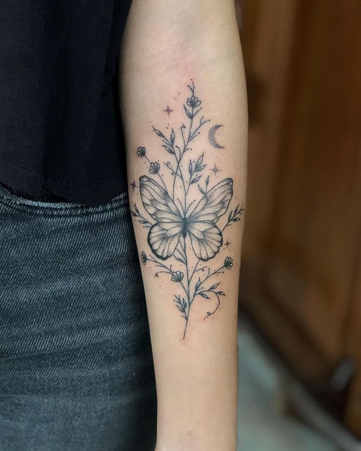 a woman's arm with a butterfly and flower tattoo on the left inner arm