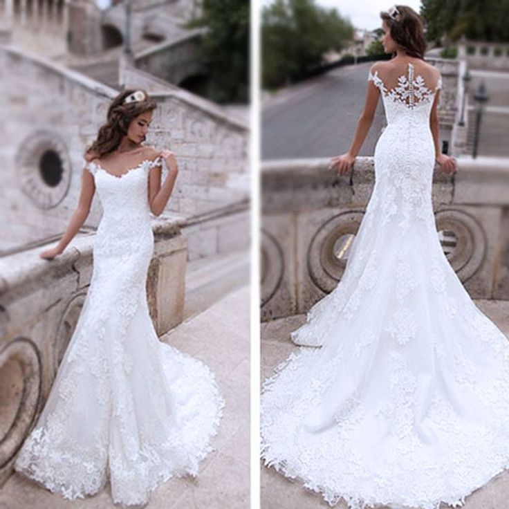 a woman in a white wedding dress standing next to a stone wall