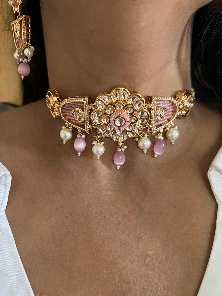 One of our favorite picks for the wedding season ♥️ The gorgeous choker is beautifully handcrafted by our skilled Indian craftsmen in Kundan stones, multi coloured beads, mini pearls, and gold plated. The beautiful Kundan earrings add to the traditional ethnicity of the piece. Material: Brass with gold plating Dimensions Weight of choker is 39 g. Choker comes with adjustable Dori. Weight of earrings is 18 g per pair. Length of earrings: 6.55 cms, push back closure. Width of earrings: 2.5 cms. Pink Kundan Fusion Jewelry, Festive Handmade Pearl Jewelry, Kundan Jewelry With Gold Beads For Party, Pink Meenakari Jewelry For Gift, Pink Gold Plated Necklace For Wedding, Pink Gold-plated Necklace For Wedding, Fusion Style Pink Jewelry For Festivals, Pink Temple Jewelry As A Gift, Pink Gold Beaded Jewelry For Party