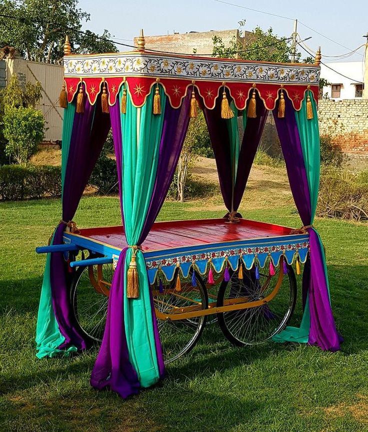 an elaborately decorated bed on wheels in the grass