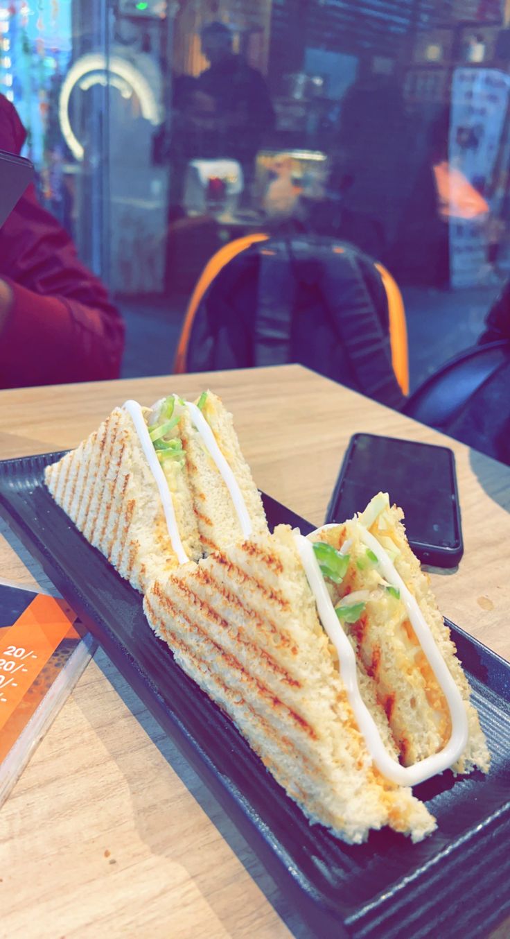 a sandwich cut in half sitting on top of a black plate