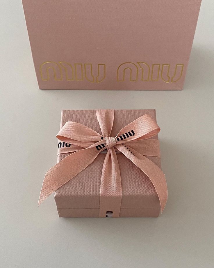 a pink gift box with a ribbon tied around it