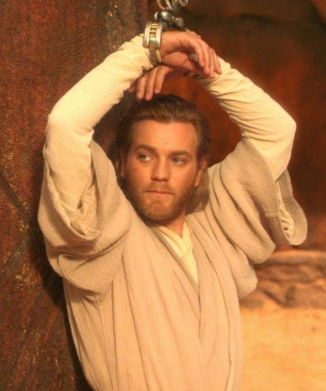 a man in a star wars costume holding his hands on his head and looking at the camera