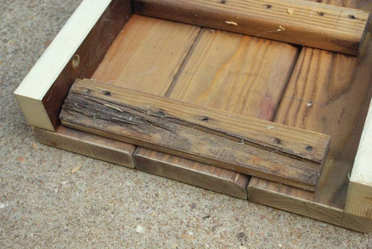 an old wooden box sitting on the ground with nails sticking out of it's sides