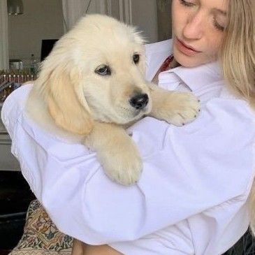 a woman holding a puppy in her arms