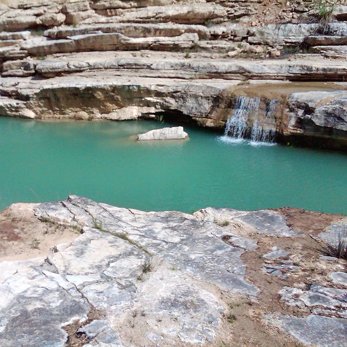 there is a small waterfall in the middle of some rocks