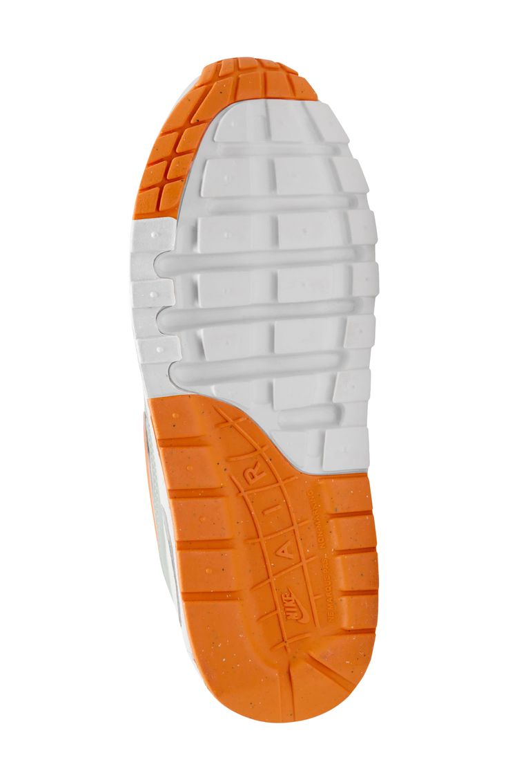 an orange and white shoe is shown on a white background with the bottom part of it showing