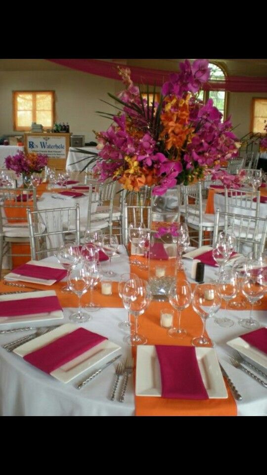 the tables are set with place settings and flowers in vases on top of them