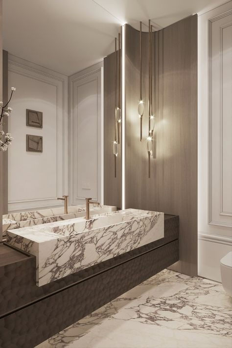 an elegant bathroom with marble counter tops and gold faucet lights on the wall