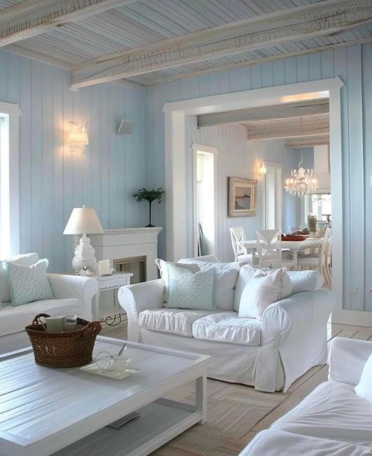 a living room with white furniture and blue walls