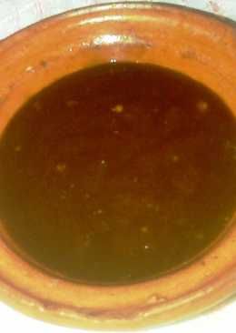 a brown bowl filled with liquid sitting on top of a table