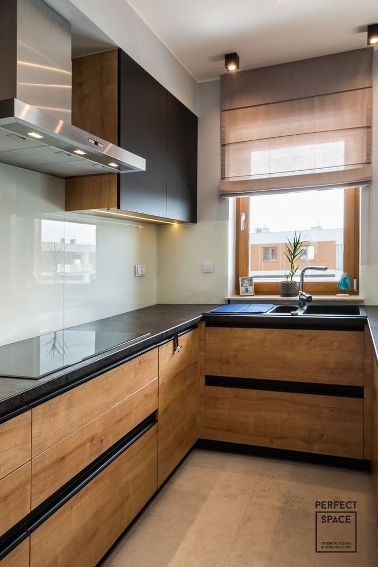 a kitchen with wooden cabinets and black counter tops