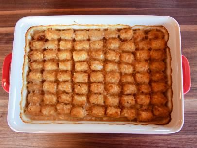 a red and white dish filled with waffles on top of a wooden table