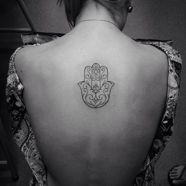 a woman with a hamsa tattoo on her back