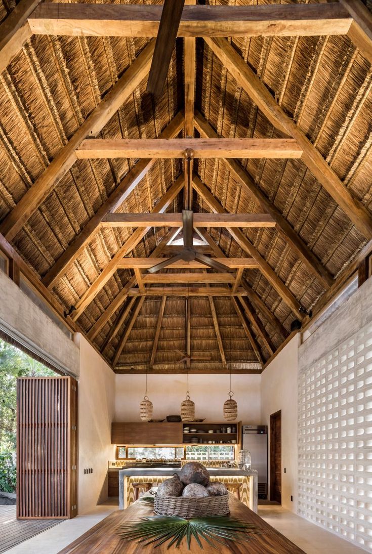 a large wooden table in the middle of a room with a ceiling made of wood