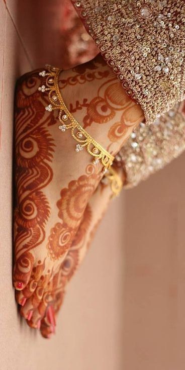 a woman's hands with henna and jewelry