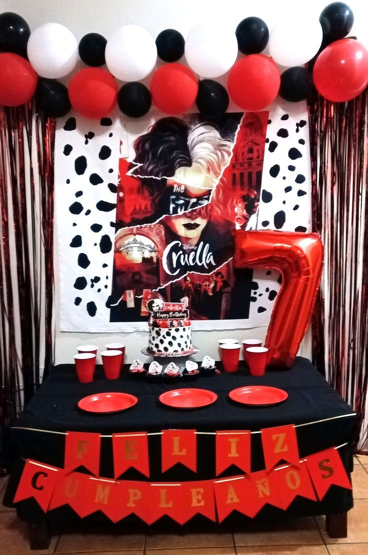 a table topped with red and black balloons next to a sign that says coca cola