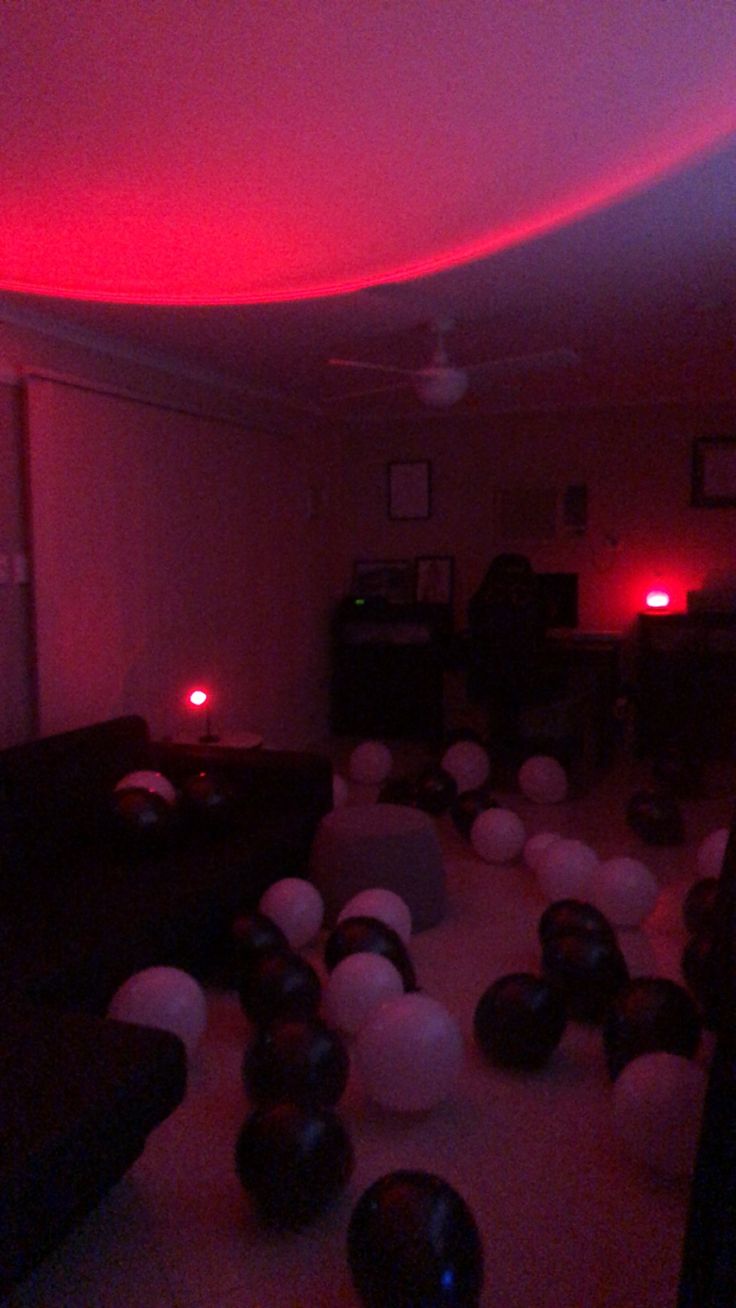 a room filled with balloons and lights in the dark