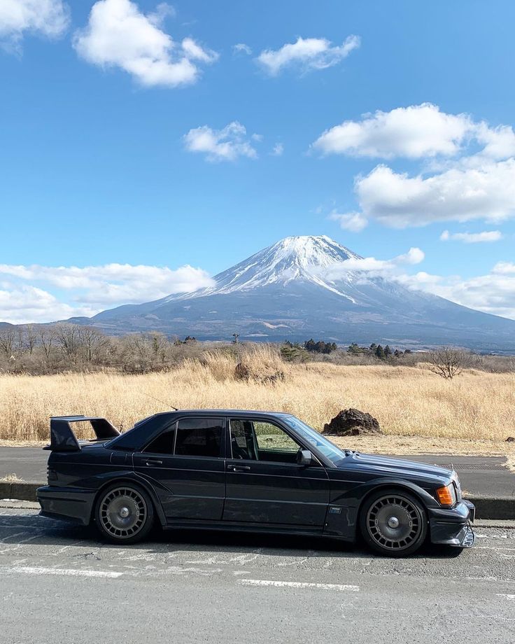 a black car parked in front of a mountain