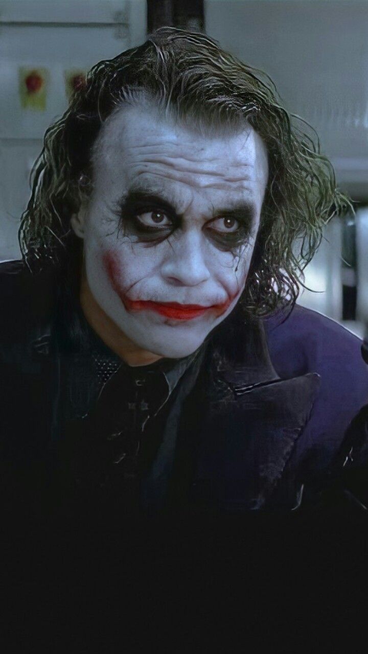 the dark knight joker with his hair in curls and makeup is looking into the camera