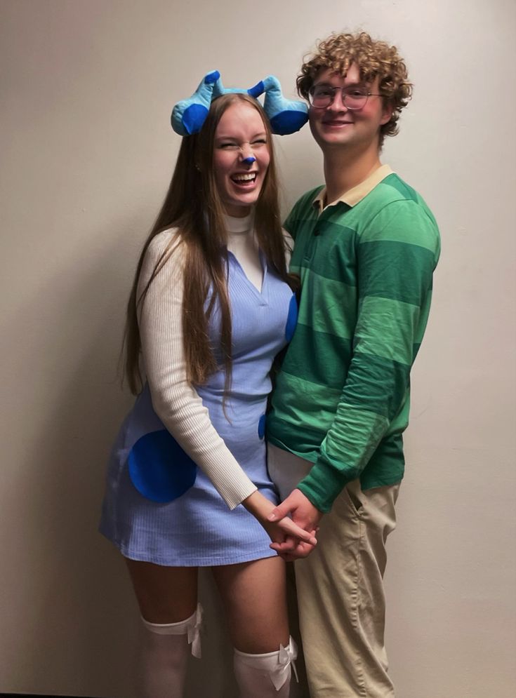 a man and woman dressed in costumes posing for a photo with their noses painted blue