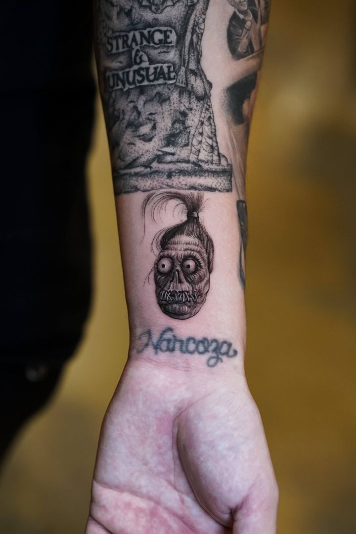 a person with a tattoo on their arm holding up a hand in front of them