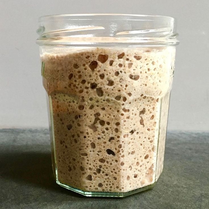 a glass jar filled with food sitting on top of a gray counter next to a white wall